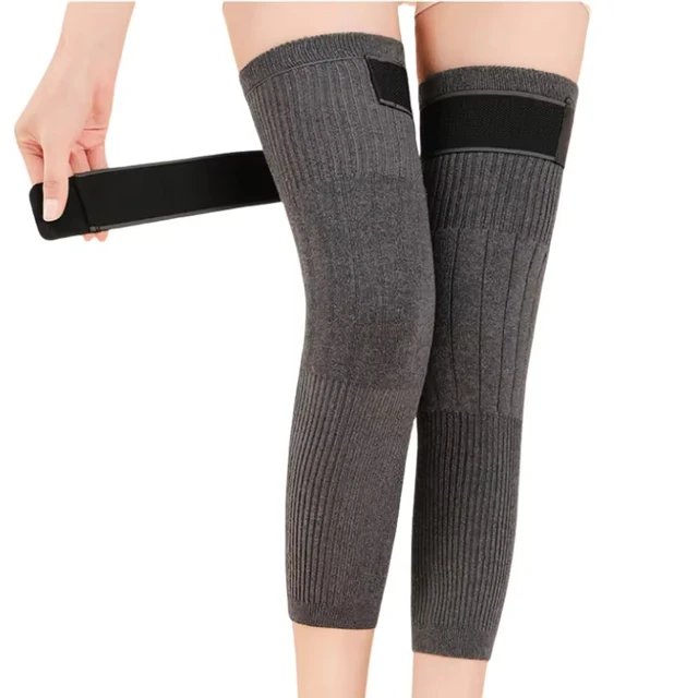 Gray knee-high socks with black bands held by a person on a white background