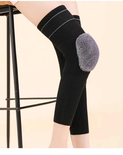 Black knee brace with gray padding on a beige background